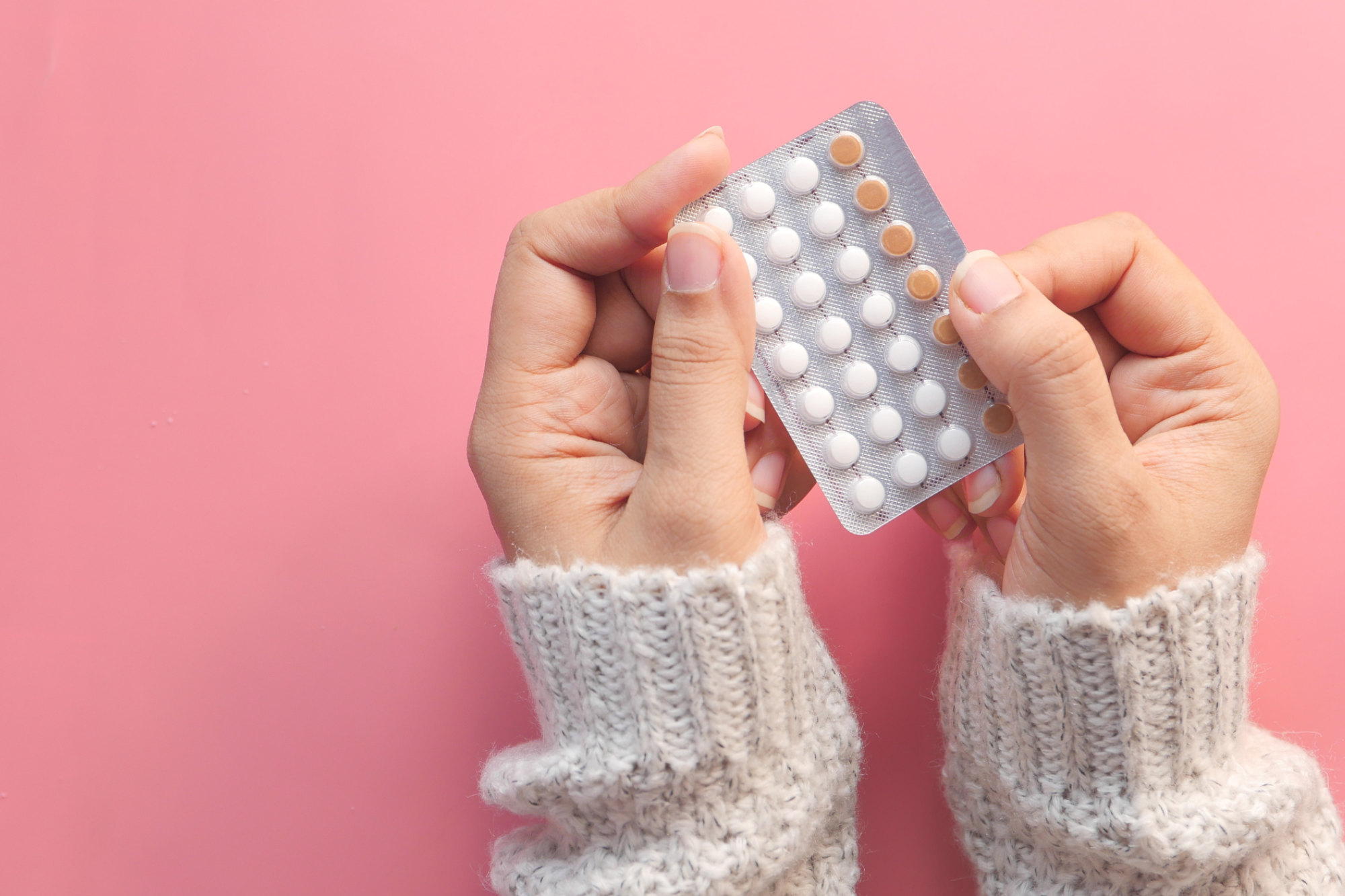 girl's hands holding birth control pills